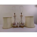 A pair of porcelain pear shaped table lamps decorated with floral clusters with gilded metal