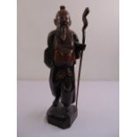 A Chinese hardwood figurine of an elder with a staff on raised square plinth