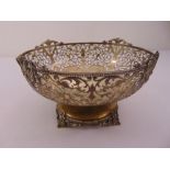 A silver fruit bowl, circular, scroll pierced sides with gadrooned border and applied floral