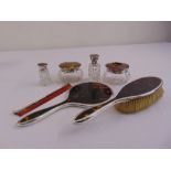 A quantity of tortoiseshell and silver dressing table pieces to include a hand mirror, a hair brush,