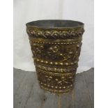A shaped oval brass umbrella stand the side embossed with flowers, leaves and scrolls to include