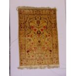 A Persian silk rectangular wall hanging decorated with flowers and leaves against a tan border, 113x