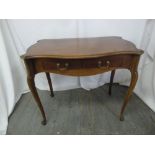 A rectangular mahogany desk with two drawers and brass swing handles on four cabriole legs