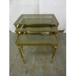 A gilded metal and glass nest of three rectangular tables on four tapering cylindrical legs