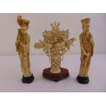 A pair of oriental carved composition figurines of a lady and gentleman and a carved floral