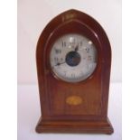 A mahogany mantle clock of lancet form with satinwood inlays, silvered dial with Arabic numerals, on