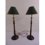 A pair of turned wooden table lamps with gilded fittings and shades