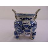 A Chinese blue and white incense burner on three paw feet with two upswept side handles