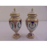 A pair of Dresden vases, ovoid form with domed pull off covers on raised circular bases decorated