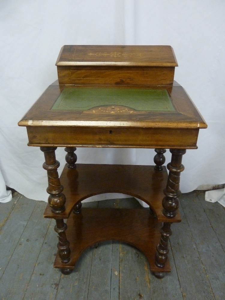 A rectangular mahogany desk with tooled leather hinged top, inlaid decoration on four turned knopped