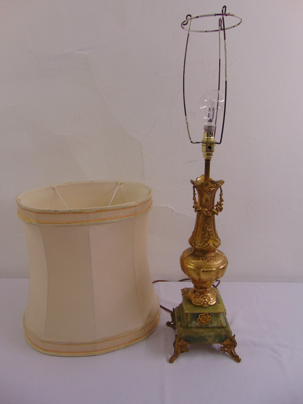 A gilded metal and onyx table lamp of vase form on raised square plinth to include silk shade