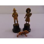 Two cast gilded metal figurines of a boy and girl and another of a lion