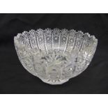 A cut glass fruit bowl with fluted sides on raised circular base