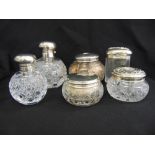 A quantity of cut glass scent bottles and powder jars with silver covers (6)