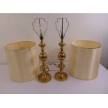 A pair of brass table lamps on raised circular base with silk shades