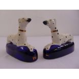 A pair of Staffordshire porcelain dogs on raised oval blue glazed bases