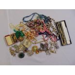 A quantity of costume jewellery to include necklaces, brooches and beads