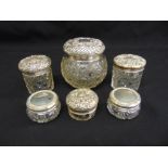 Six cut glass dressing table jars with silver covers