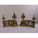 A pair of cast brass fire dogs in the form of classical vases on a balustrade