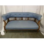 A Victorian upholstered settle with scroll pierced struts on four turned legs