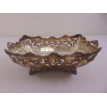 A Victorian silver shaped rectangular roll basket with scroll pierced sides, chased with flowers and