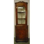 An Edwardian mahogany glazed corner cabinet on four bracket feet