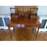 A mahogany Chinese style rectangular desk with gallery on turned cylindrical legs with castors