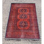 Persian wool carpet red ground with repeating geometric border, 142 x 100cm