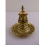 A 19th century brass ink stand, the circular base supporting a cylindrical well with domed hinged
