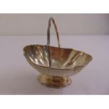 A Victorian silver sugar basket, oval with beaded borders and swing handle on raised oval base,