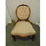 A Victorian upholstered button back boudoir chair on scroll legs