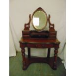 A Victorian mahogany shaped rectangular dressing table with oval swivel mirror above five drawers on