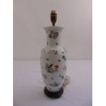 An ovoid oriental style table lamp decorated with floral sprays on hardwood stand