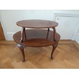 An Edwardian oval two tier mahogany tea table on cabriole legs
