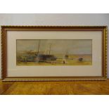 A framed and glazed watercolour of fishing boats on a beach, monogrammed bottom right, 15.5 x 45cm