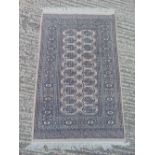 A Bokhara wool carpet, brown ground with repeating geometric pattern, 149 x 96cm