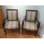 A pair of mahogany upholstered armchairs with scrolling arms and legs