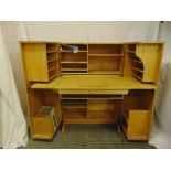 A 1960s light oak rectangular desk cum cupboard, the hinged doors revealing book and stationery