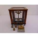 A cased Rekar Medical balance scale in glazed mahogany case on four ball feet to include weights