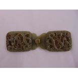 A Chinese green jade belt buckle carved and pierced with flowers and leaves