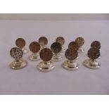A set of twelve Chinese white metal place name holders on raised circular bases, stamped sterling