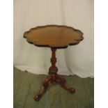 A mahogany wine table, shaped circular top with Chippendale style border on three scroll legs