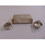 A silver cigarette box, a silver napkin ring and a silver tea strainer