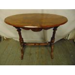 A Victorian walnut and mahogany oval occasional table on turned columns and outswept legs