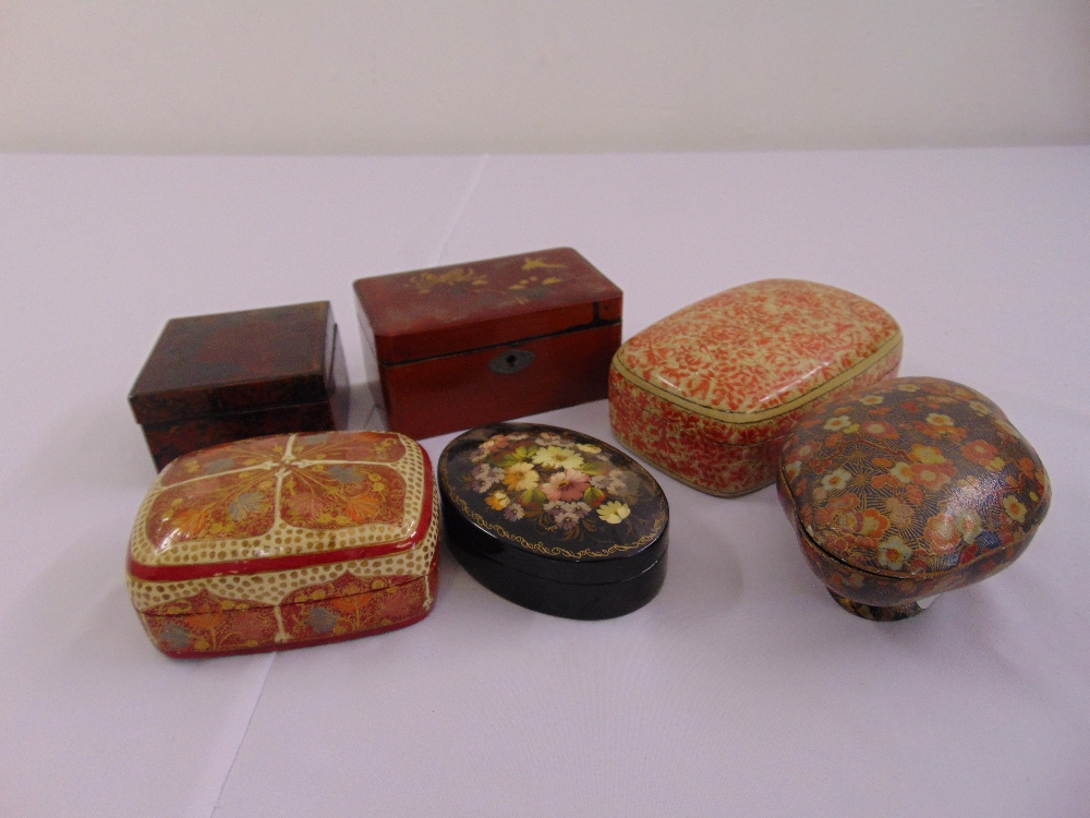 Six papier mache covered boxes of various shape, colours and form