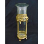 A gilded metal and cylindrical glass lantern on four claw feet
