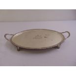 A George III silver oval tea tray, gadrooned border with scroll side handles, engraved armorial to