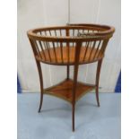 An oval wooden plant stand with slatted sides, swing handle on four cabriole legs