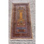 Persian style wool pink and brown ground prayer rug with repeating geometric design and border,