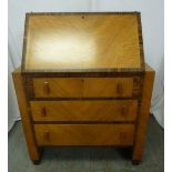 A rectangular Art Deco satinwood bureau with coromandel borders, three drawers with Bakelite handles